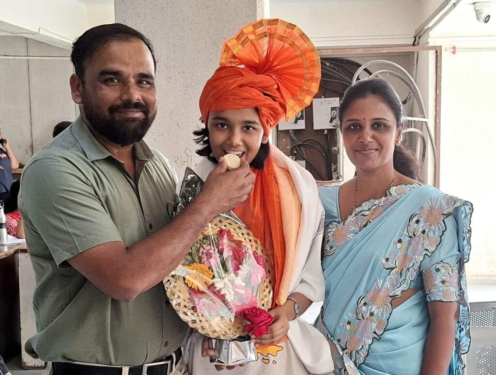  पेढा भरवून अनार्याचे कौतुक करताना तिचे आई वडील.